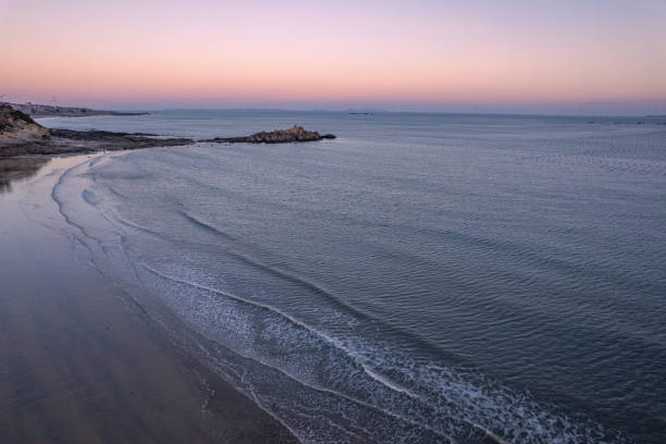 Overlooking the beache and waves along the dusk coastline