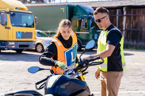 istock Student and instructor, exam in motorcycle school. Male instructor teaching a student how to operate a motorcycle 2156574166