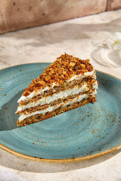 istock Authentic Carrot Cake Slice in Natural Sunlight on Blue Plate, Beige Background Still Life 2156575005