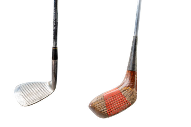 Close-up of top of golf bag containing a selection of clubs, covered and uncovered, against an out-of-focus golf course background with lots of copy space..