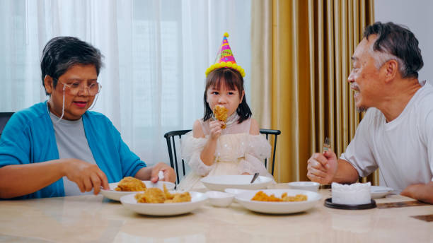 Grandparents Celebrating Birthday With Granddaughter At Home.