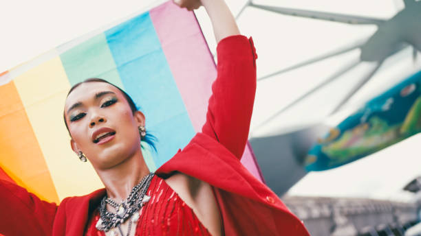 Man walking and waving rainbow flag during LGBTQI parade.