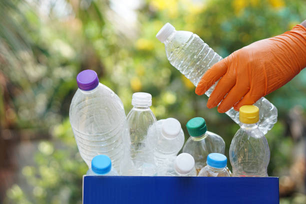 istock Hand holds used plastic bottle to put in junk bin for recycling. Concept, sorting garbage campaign before throw away 2156588878