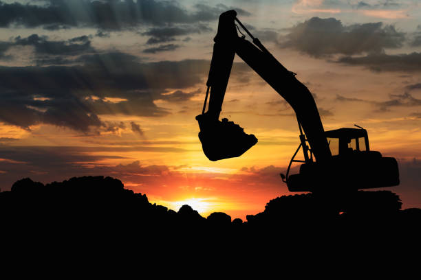 istock Excavators silhouette are digging the soil in the construction site . 2156593315