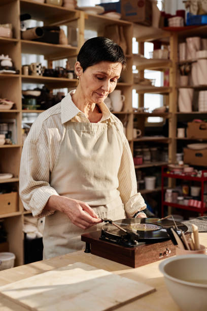istock Woman Setting Up Music in Cozy Art Studio 2156595409