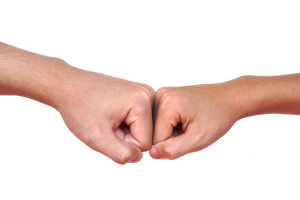 Close up two hands bump their fists together for greeting. Concept, Body language. Hands gesture symbol for greeting, giving respect or approval as companionship between two people.