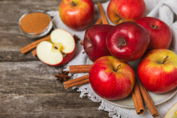 istock Apples with cinnamon on a textured wooden background. Fragrant red spiced apples with cinnamon sticks and star anise. Apple slices with spicy spices. Place for text. Copy space. Harvesting. Fruits. 2156605420