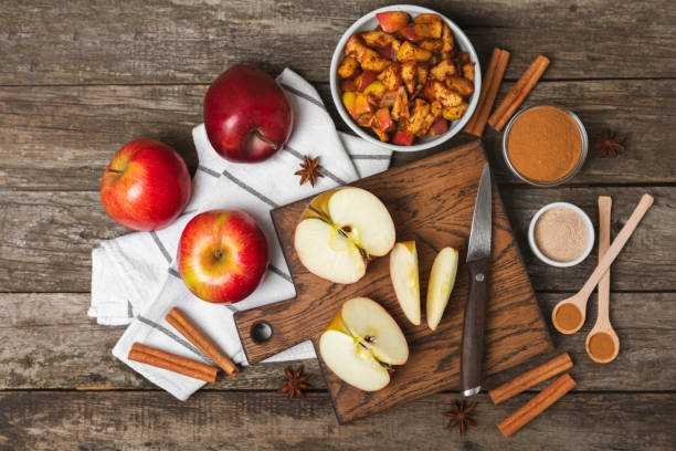 istock Apples with cinnamon on a textured wooden background. Fragrant red spiced apples with cinnamon sticks and star anise. Apple slices with spicy spices. Place for text. Copy space. Harvesting. Fruits. 2156605434