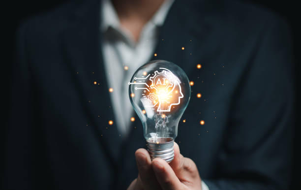 istock hand holding a light bulb. artificial intelligence or AI of future innovation technology concept, applying technology to business in the digital age. empowering global business AI. 2156605522