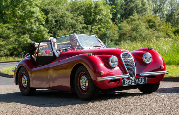 Stony Stratford,UK - June 2nd 2024: 2007 red Nostalgia XK120, Jaguar XK120 replica,car driving on a British country road