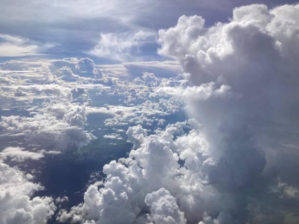 istock View of the city below and large white clouds with the bright sun rays 2156605940
