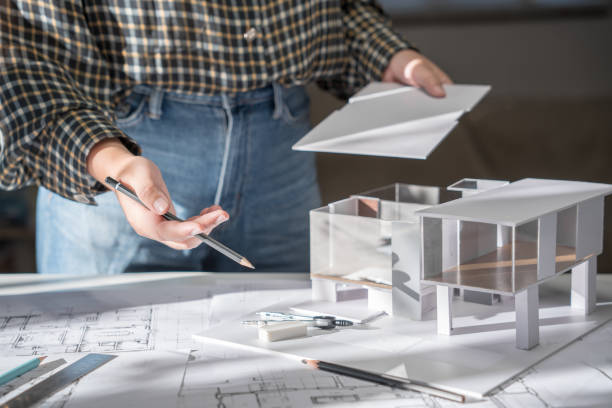 istock House model on Buleprint construction drawing and drawing equipment stationary Architect analyzing house modelÂ house modern in hand Architect Design 2156606868