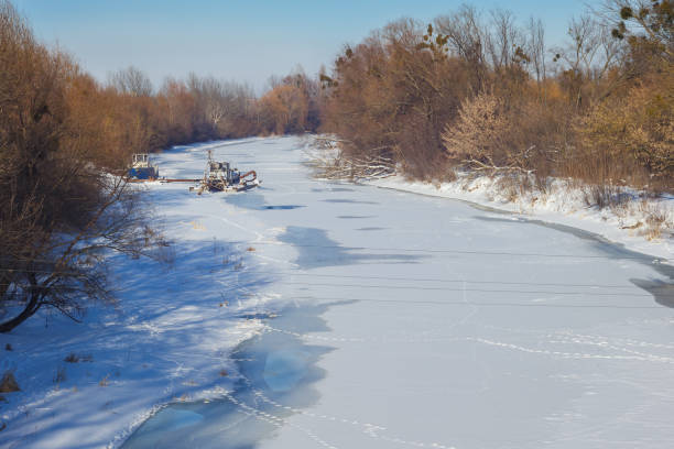 Frosty snowy winter landscape in the IJsseldelta during an early sunny morning with frozen reed near the river IJssel close to Kampen, in Overijssel, The Netherlands.