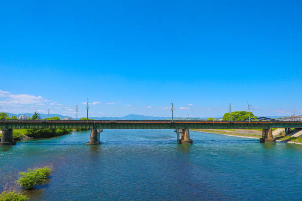 Scenery of Kyoto's Uji area - horizontal photography. Train track railway over a wide river at Uji Kyoto.