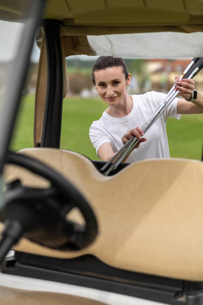 istock Attractive golfer woman posing on course at golf car 2156625518