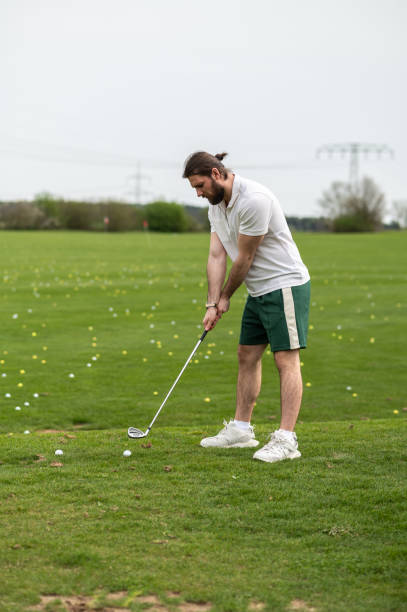 istock Man with golf ball on lawn for game enjoying match and competition on golfing course 2156625542