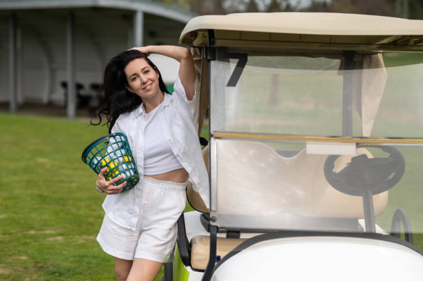 istock Active woman posing with golf gear by the vehicle outside 2156625549