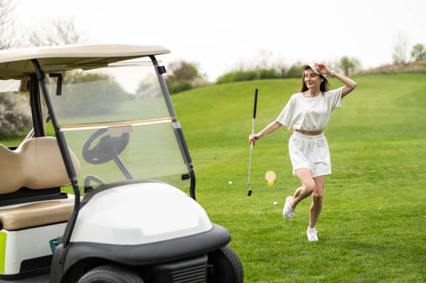 istock Active woman posing with golf gear by the vehicle outside 2156625637