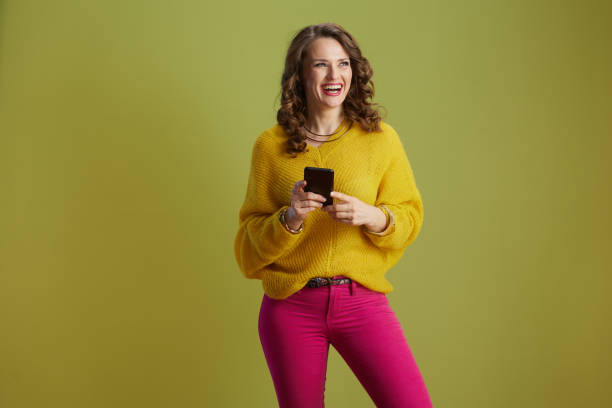 istock happy 40 years old woman using smartphone isolated on green 2156631631