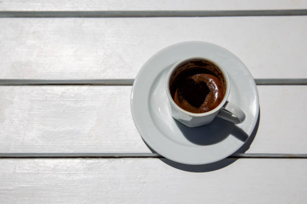 Espresso or coffee in white cup on white wooden table copy space top view
