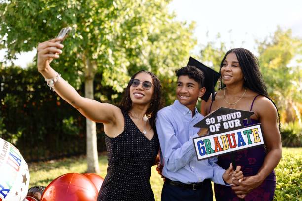 Smiling family taking selfies with a graduate