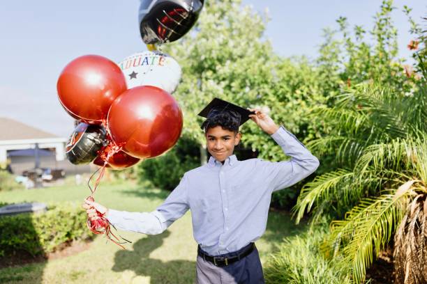 Happy boy posing with balloons on a graduation day