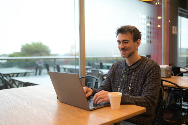 istock young man working with his laptop in a coffee shop 2156641660