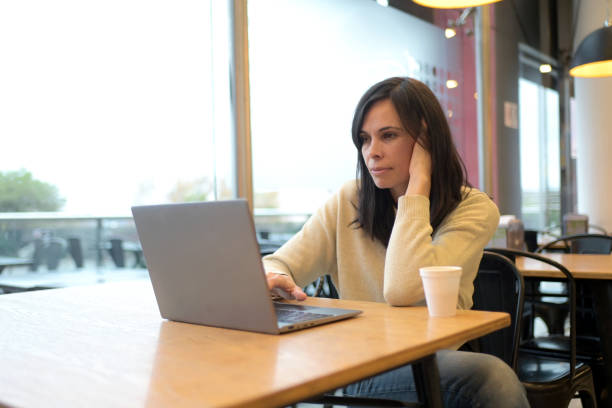 istock woman working with her laptop in a coffee shop 2156641775