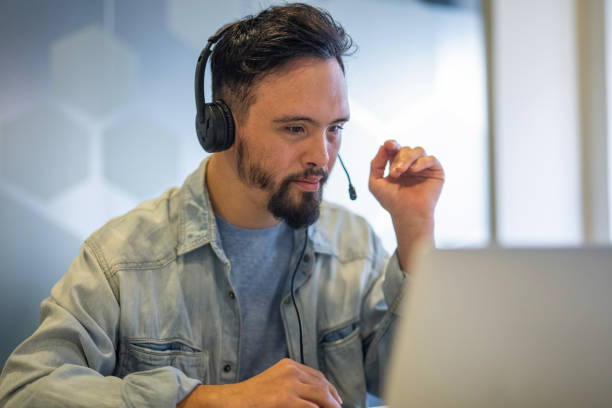 istock Young man wearing headset while participating in video call at inclusive office 2156646539