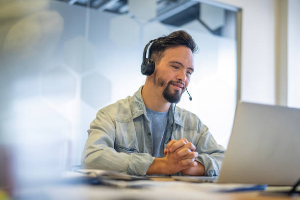 istock Young man wearing headset while participating in video call at inclusive office 2156646558