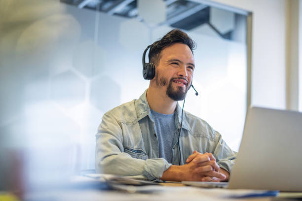 istock Young man wearing headset while participating in video call at inclusive office 2156646718