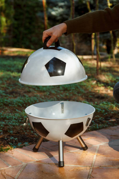 istock Hand open lid on round grill in yard 2156650685