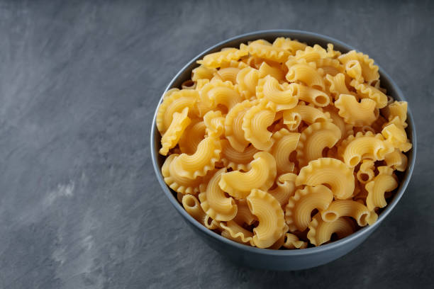 istock Raw Creste di Gallo Pasta in Ceramic Bowl on Dark Concrete Background, Copy Space 2156656326