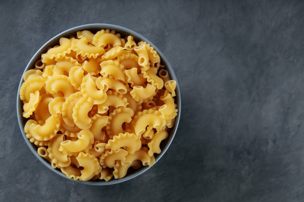 istock Raw Creste di Gallo Pasta in Ceramic Bowl on Dark Concrete Background, Copy Space 2156656343