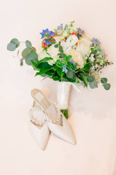 istock White wedding shoes and the bridal bouquet on a plain white background. 2156658967