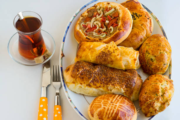 Top view of Traditional Turkish pastry,patty various for breakfast with tea on white surface with cutlery set
