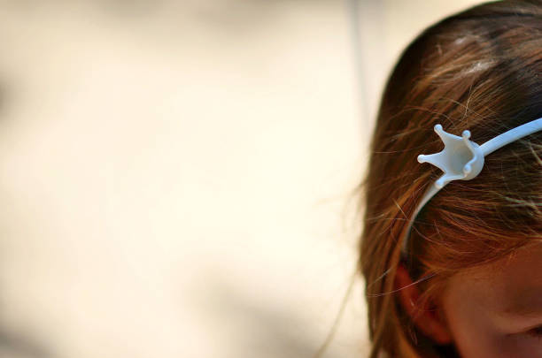 A girl with a crown on her head. The crown is white and a girl is celebrating his birthday as a little princess.