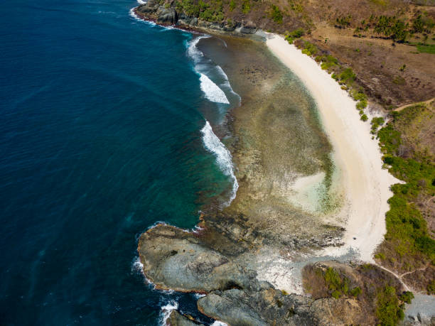 istock Aerial view of a small, empty tropical beach surrounded by blue ocean (Semeti Beach, Lombok) 2156671755