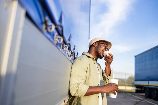 istock Truck driver enjoying cheeseburger on lunch break. 2156672129