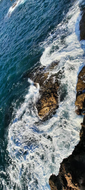istock Waves Crashing Against the rocks 2156674712