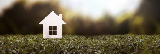 istock paper house on a lawn - property purchase concept 2156675023