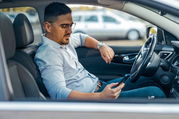 istock Businessman checking phone in driver's seat 2156675866