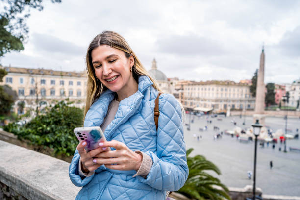 istock Woman using phone in front of a Piazza del Popolo, Rome 2156676632