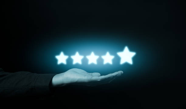 istock Five-Star Customer Review Satisfaction Concept. Hand presenting glowing five-star icons against a dark background, symbolizing customer review, satisfaction, and feedback survey in a digital context. 2156677146