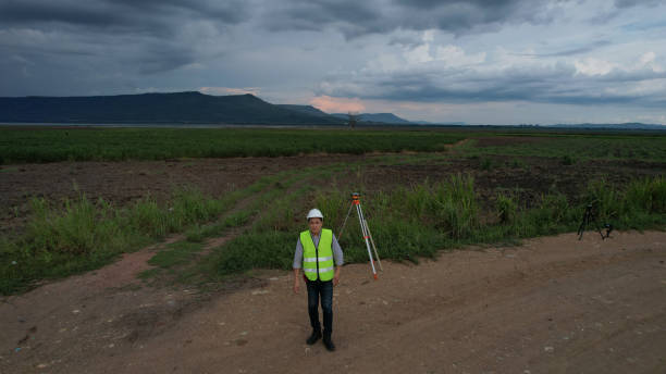 istock High-angle view of Civil or construction engineer using a survey camera or an engineer with an auto-level camera  at construction site 2156678060