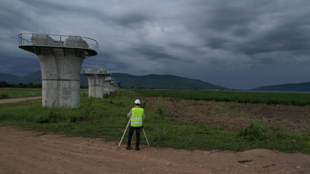 istock High-angle view of Civil or construction engineer using a survey camera or an engineer with an auto-level camera  at construction site 2156678084