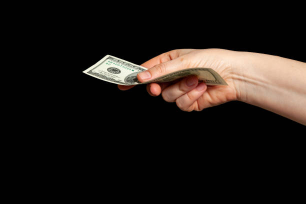 istock Hand holding paper dollars on black background 2156679106