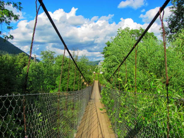 White rope bridge spanning over a body of water.