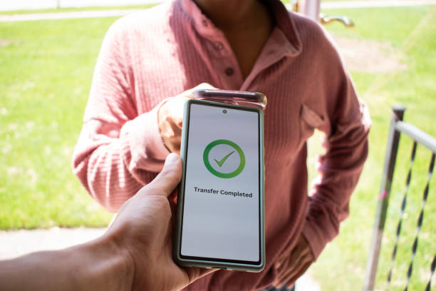 istock Hand using smart device to make a transfer- stock photo 2156686715