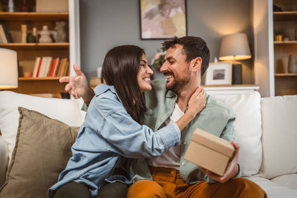 istock Boyfriend open his birthday present from his girlfriend at home 2156686788